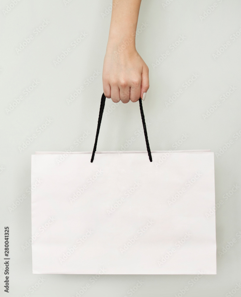 Woman holding paper bag on gray background Woman holding paper bag on gray background
