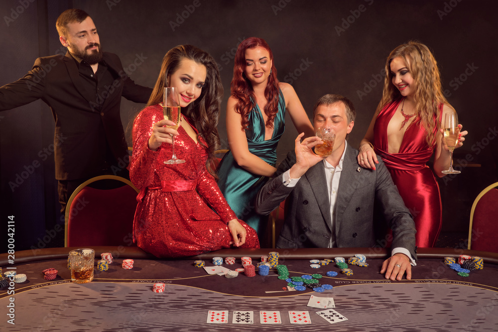 Group of a young wealthy friends are playing poker at a casino. Group of a young wealthy friends are playing poker at a casino.