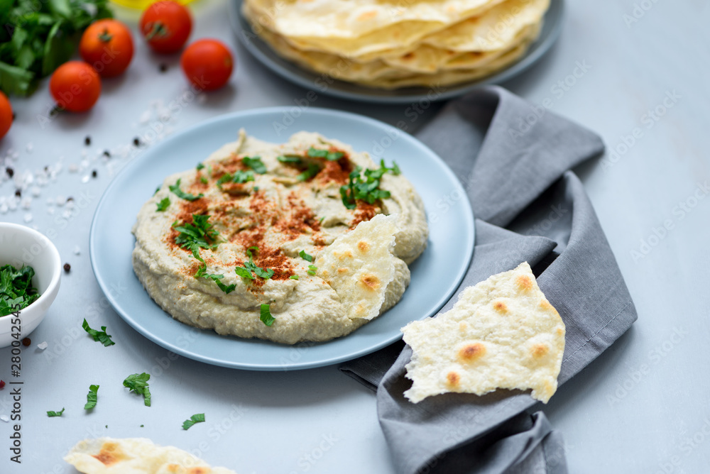 Eggplant dip baba ganoush (mutabbal) with herbs and paprika on gray wooden background. Selective focus. Traditional arabian food Eggplant dip baba ganoush (mutabbal) with herbs and paprika on gray wooden background. Selective focus. Traditional arabian food
