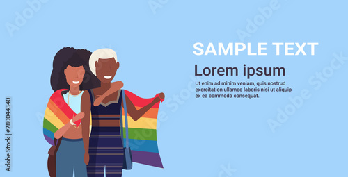 women couple holding rainbow flag love parade lgbt pride festival concept african american lesbians embracing female cartoon characters standing together portrait horizontal copy space