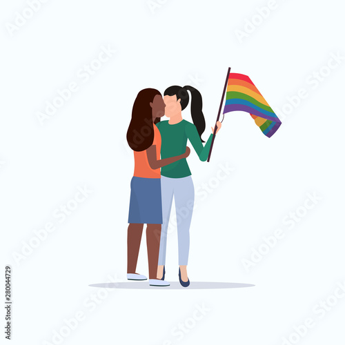 women couple holding rainbow flag girls kissing love parade lgbt pride festival concept mix race lesbian female cartoon characters standing together full length flat