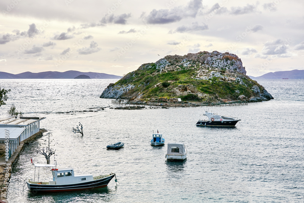 Rabbit island, fishing boats and Aegean sea in Bodrum, Gumusluk, Mugla, Turkey on a winter day.