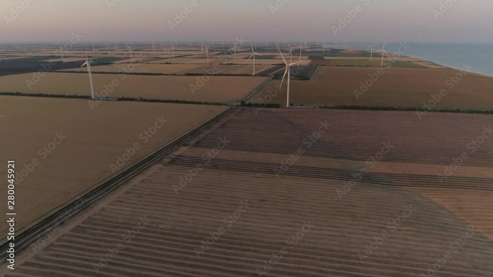 Aerial view of Wind turbines Energy Production - 4k aerial shot on sunset. 4k drone footage turbines at sunrise Aerial view of Wind turbines Energy Production - 4k aerial shot on sunset. 4k drone footage turbines at sunrise