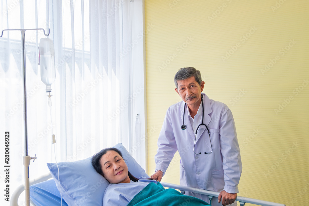Happy and Smile, Senior asian male doctor visiting middle-aged female patient on Ward. in room hospital. concept healthcare and medicine.