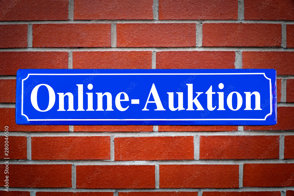 Online Auktion Schild blau an Backsteinwand Online Auktion Schild blau an Backsteinwand