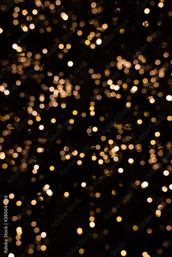 Blurry golden and white fairy lights in dark night creating beautiful bokeh  effect with glowing circles or shiny dots, abstract image for Christmas or  holiday card, banner or background Stock Photo