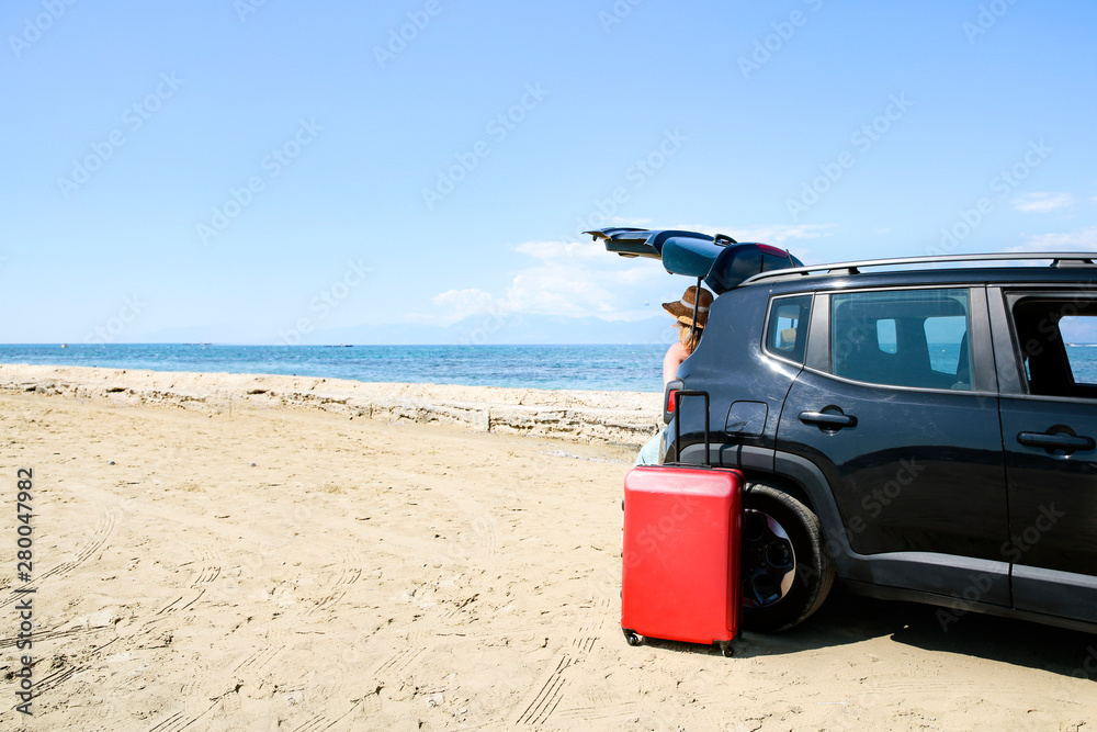 A woman weraing sunglasses and a hat in the summer car on the beach and ocean view.. A woman weraing sunglasses and a hat in the summer car on the beach and ocean view..