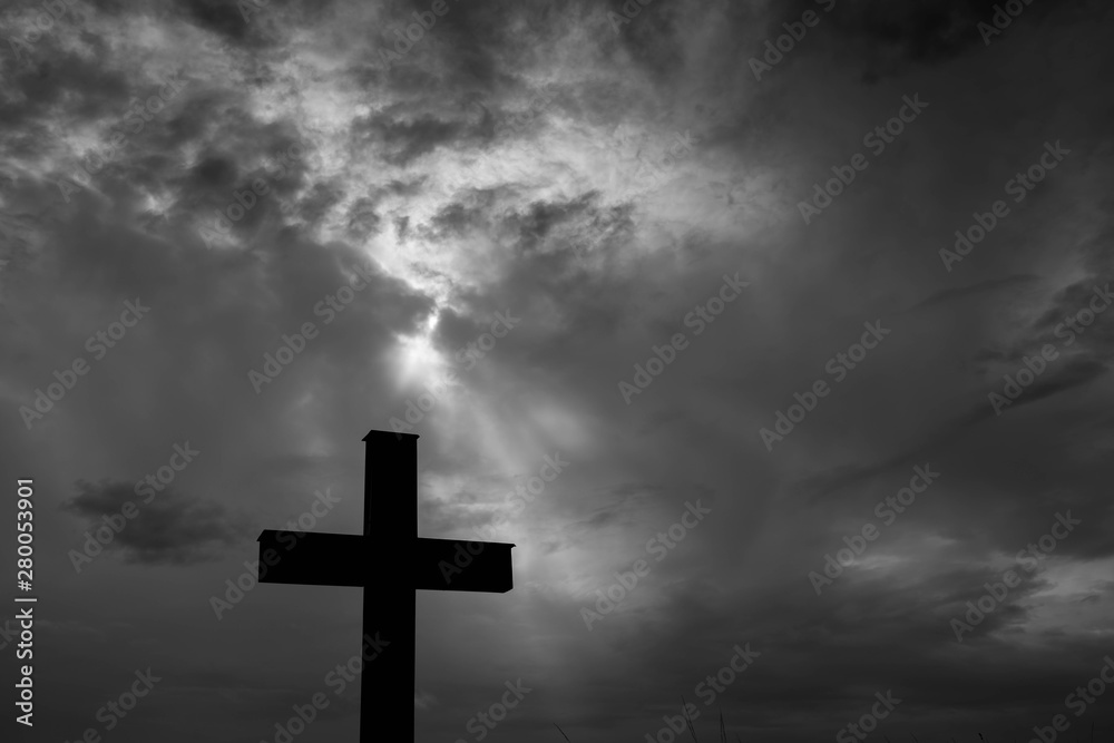 Silhouette of a simple catholic cross, dramatic stormclouds after heavy rain, copy space in black and white. Silhouette of a simple catholic cross, dramatic stormclouds after heavy rain, copy space in black and white.