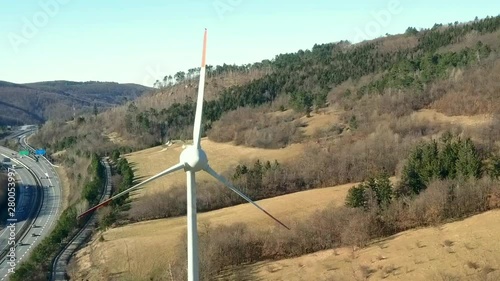 VIPAVA, SLOVENIA, 2017.08.22: Aerial: Flying arround wind turbine beside highway. Filmed while flying with drone in Karst region in Slovenian seaside.