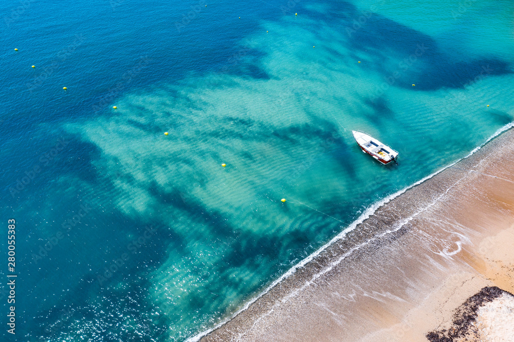 Aerial view of a boat on water and sandy coastline view