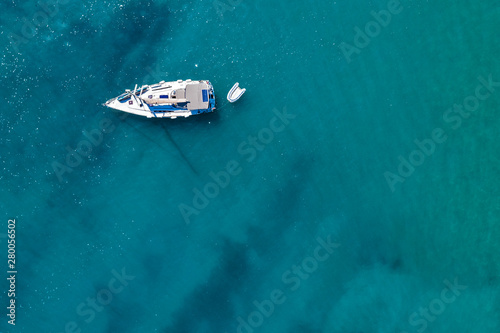 Fototapeta Naklejka Na Ścianę i Meble -  Aerial view of a boat on water and sandy coastline view