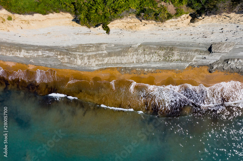 Aerial view of beautiflul rocky cliff and sandy beach by the ocean. photo