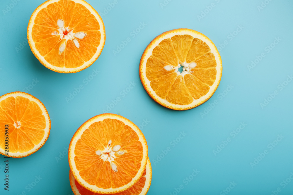 Round slices of juicy orange on a blue background, top view as a background substrate. Food background Round slices of juicy orange on a blue background, top view as a background substrate. Food background