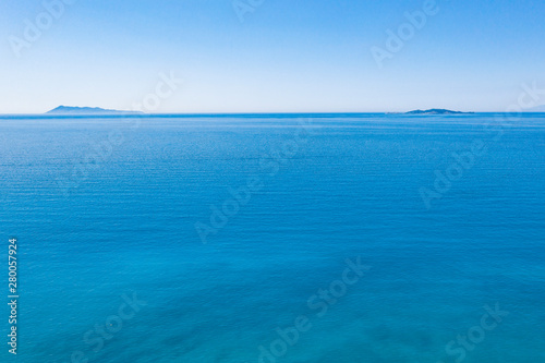 Aerial view of beautiflul rocky cliff and sandy beach by the ocean.