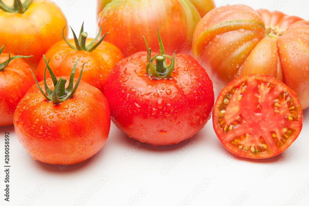 Fototapeta premium Conjunto de tomates maduros y medio tomate abierto por la mitad.
