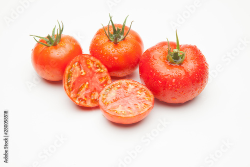 Conjunto de tomates maduros y medio tomate abierto por la mitad.