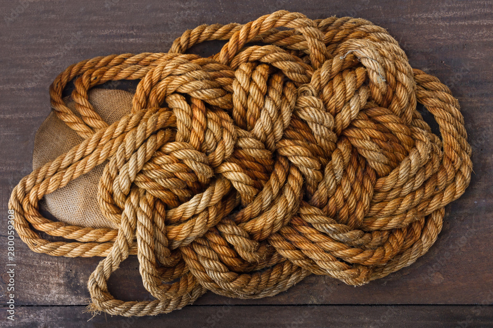 Ropes jute tackle on brown wooden background texture