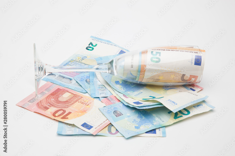 Obraz premium Copa de champagne, llena de billetes de dinero de curso legal. Copa de cristal llena de dinero y dinero encima de una superficie.