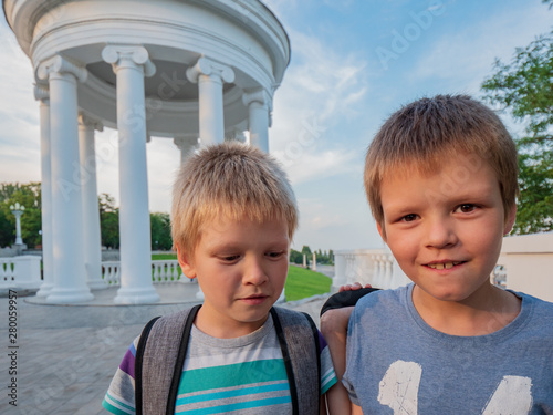 Children with school bags walk along the promenade. Happy pupil go back to school. Start new education year after vacation.  Education for kindergarten and preschool kids photo