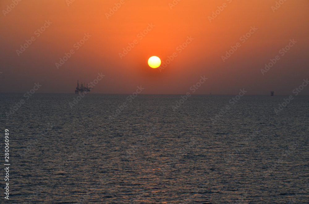 Fototapeta premium Sunset in persian gulf with oil platform