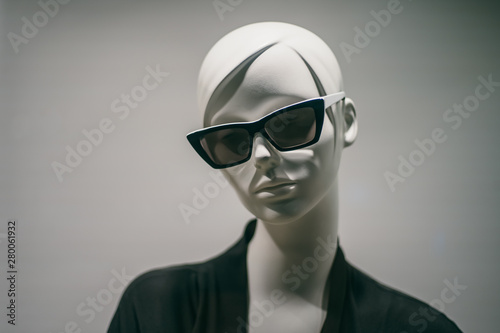 Female mannequin in sunglasses in boutique. Dummy head close up in fashion store