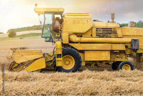 combine and a tractor during the harvest