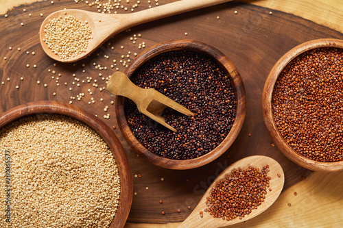 close up view of white, black and red quinoa in wooden bowls with spatula and spoons © LIGHTFIELD STUDIOS