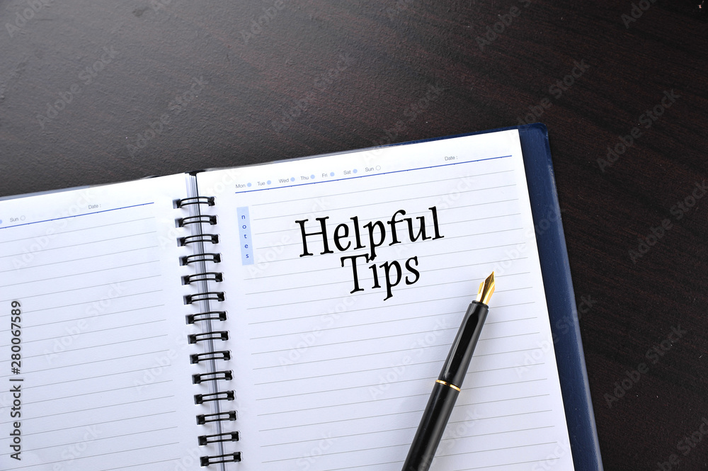 Notebook with fountain pen on wooden table with word Helpful Tips