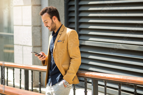 handsome young adult man in a suit with a phone in his hand © Alexandr