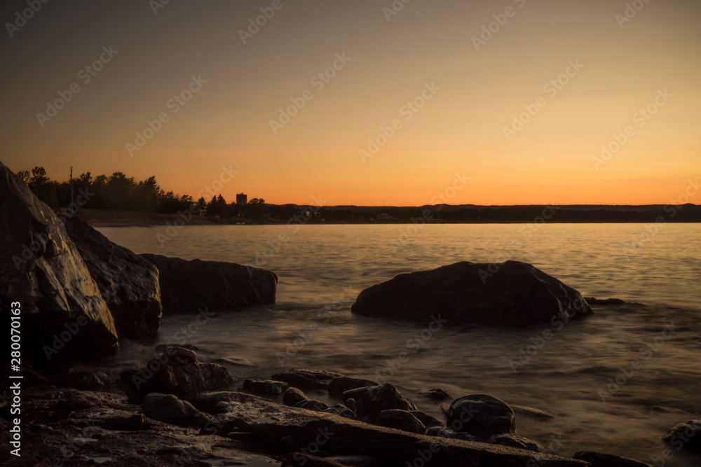 Sunset of lake rocks on shore