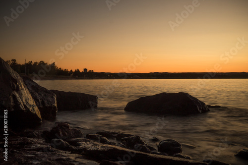 Sunset of lake rocks on shore