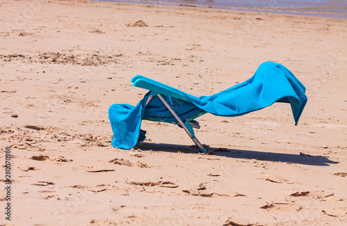 HAMMOCK AND TOWEL ON THE SHORE OF THE BEACH DURING SUMMER HOLIDAYS