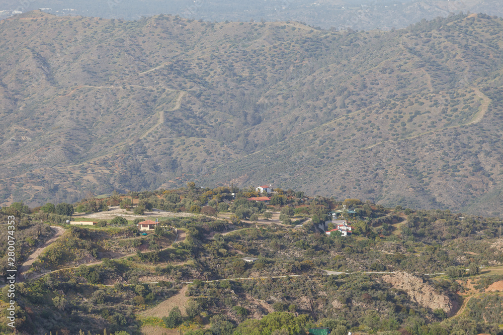 Traditional rural greek scenic mountaine view, olives and other trees grow on slopes, houses with red roofs