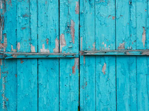 Old turquoise painted wooden doors with peeled faded paint