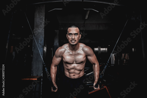 Portrait of asian man big muscle at the gym,Thailand people,Workout for good healthy,Body weight training,Fitness at the gym concept,Prank to abdominal muscles,Lift up dumpbell photo