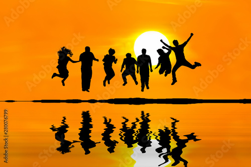 Silhouette of happy people jumping over sunset  concept about having fun