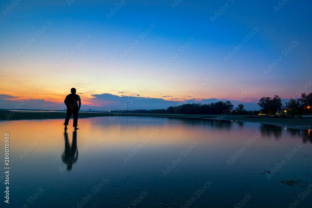 Silhouette of a men looking to the beautiful sky during sunset
