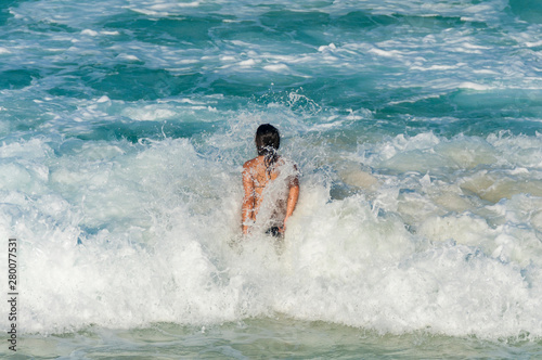 Girl faces crashing waves in Mexican Caribbean, cancun © Iván Gabaldón