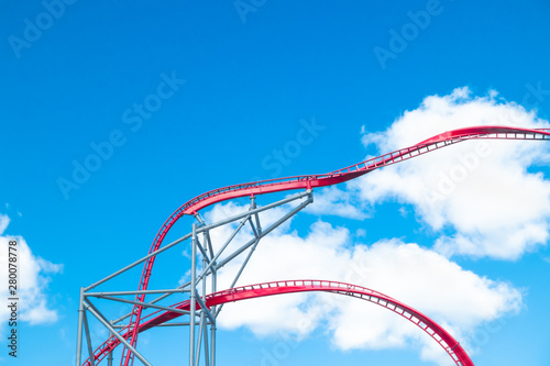 Roller Coaster in amusement park on blue sky background photo