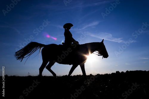 Silhouette cowgirl on horse at sunset in blue (11)