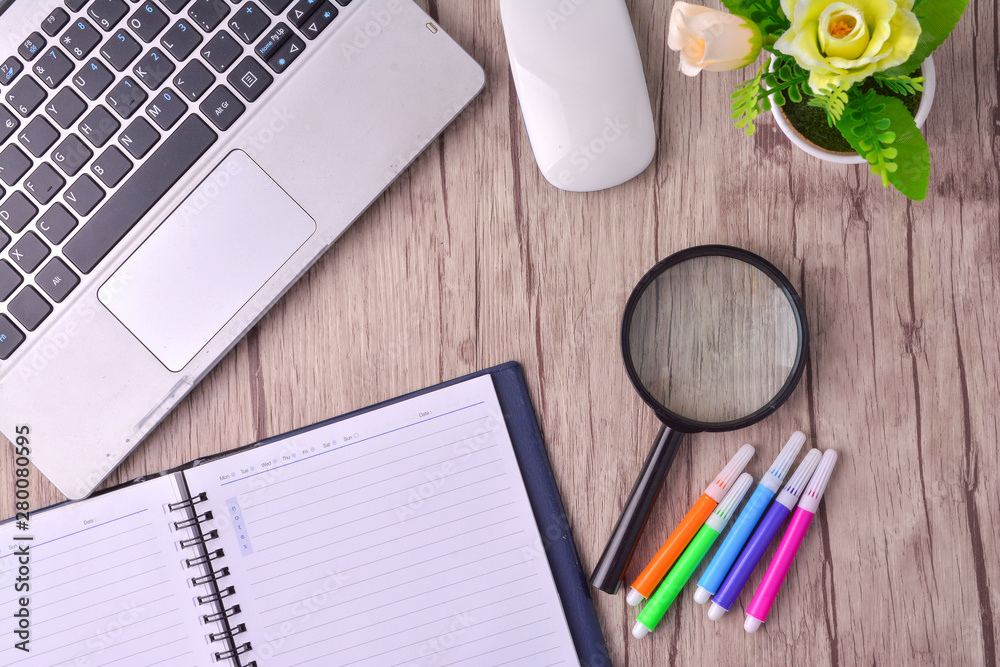 Laptop, notebook with magnifying glass on wooden table Laptop, notebook with magnifying glass on wooden table