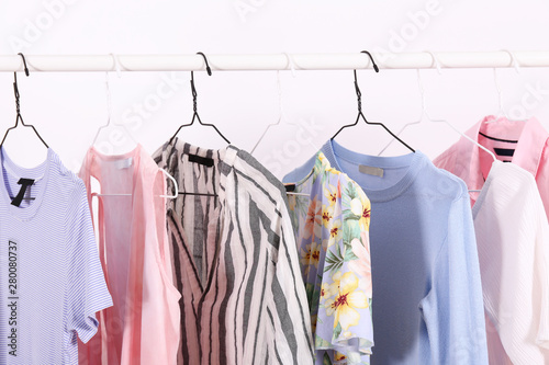 Women's hip clothing store interior concept. Row of different colorful female clothes hanging on rack in hipster fashion show room in shopping mall. Background, copy space for text. © Evrymmnt