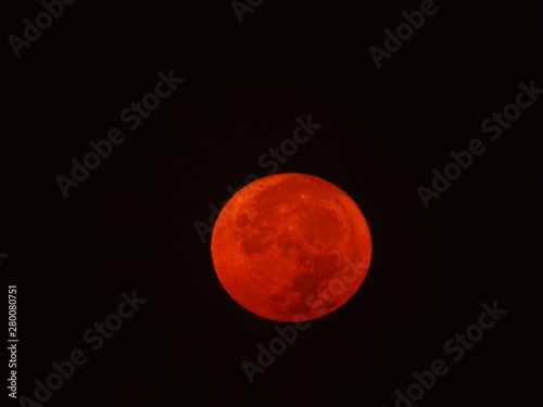 luna llena color rojo sobre fondo negro photo