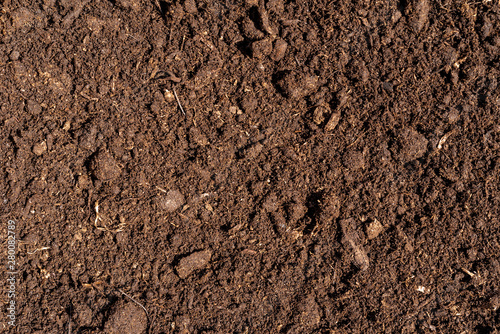 Brown crushed peat, fertilizer and soil component - background for agriculture