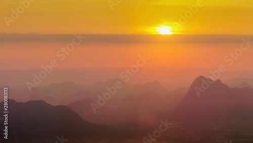 Mountain view morning of top hill around with soft fog and yellow sun light in the sky background, sunrise at Nok Aen Cliff, Phu Krakueng National Park, Loei, Thailand. photo