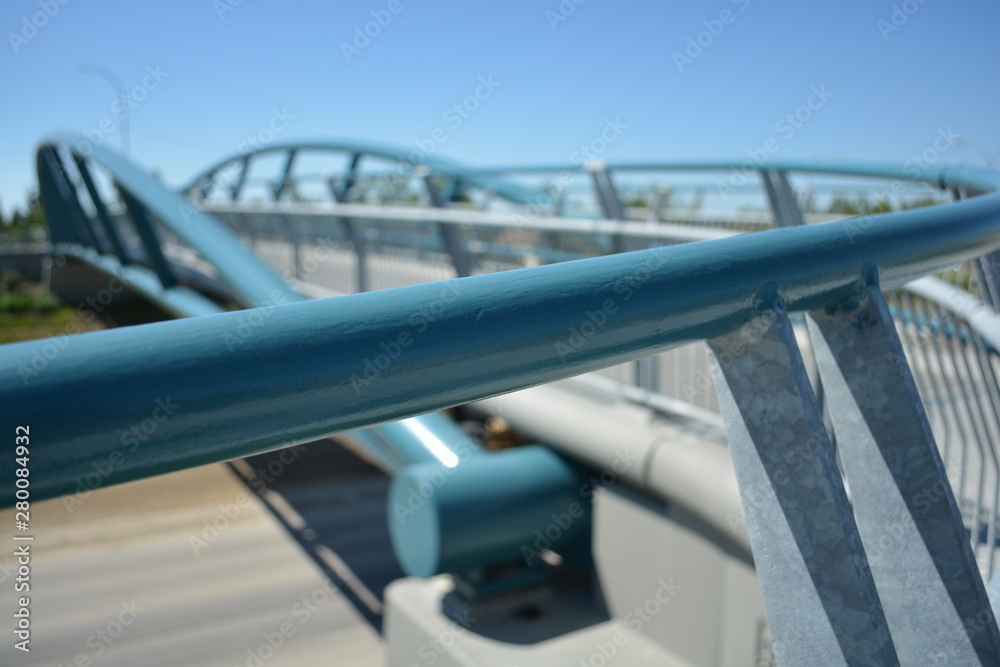 Pedestrian handrail in focus with bridge in background