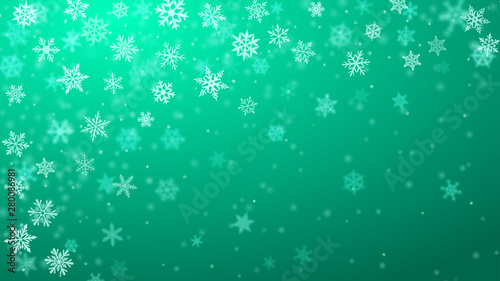 Christmas background of complex blurred and clear falling snowflakes in turquoise colors with bokeh effect