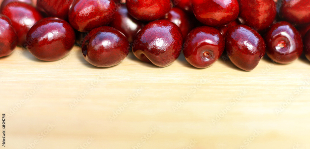 Fruits. Ripe red sweet cherry on a light wooden background. Fruits. Ripe red sweet cherry on a light wooden background.