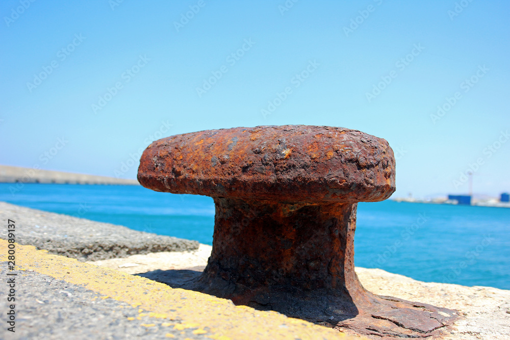Rusty wide capstan in harbor