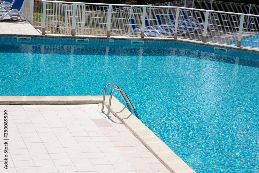 Steps ladder steel of corner in blue swimming pool